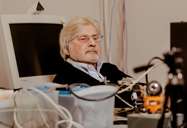 Dr. Stephen Thaler at his desk, surrounded by computer monitors and laboratory equipment